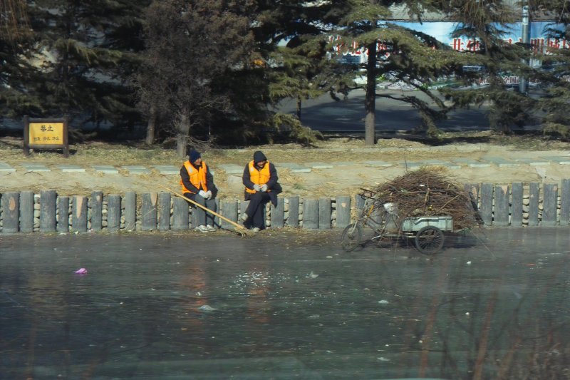 Mittagspause Straßenkehrer auf zugefrorenen Fluß